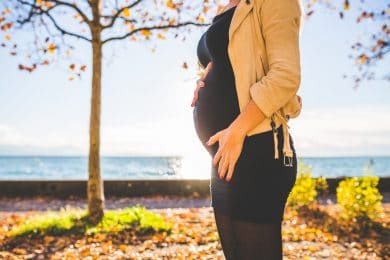 Gravid dame ved havet i solen