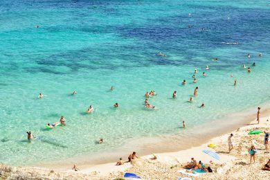 strand med en masse badende mennesker